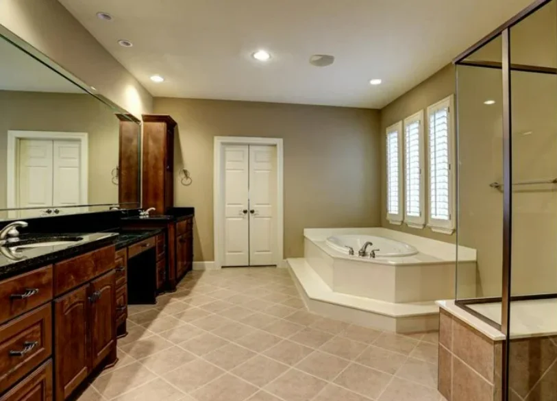Bathroom Remodel Fort Worth TX – Spacious Traditional Bathroom Traditional bathroom in Fort Worth with wooden cabinets, large mirror, corner bathtub, and glass shower before remodel