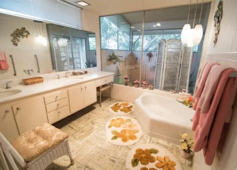 Bathroom Remodel Fort Worth TX – Traditional Floral Design Traditional Fort Worth bathroom with floral rugs, white cabinetry, corner bathtub, and pink towels before renovation